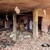 A man walks through the rubble as they inspect a house that was hit by an artillery shell