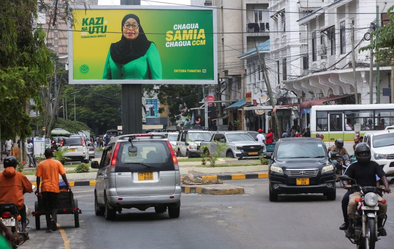 Motorists drive past an electoral campaign billboard of Tanzania's President Samia Suluhu Hassan of the ruling CCM ahead of the general elections in Ilala district of Dar es Salaam